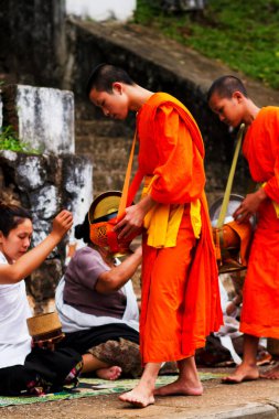 LUANG PRABANG, LAOS - SEPTEMBER15; Tanımlanamayan keşişler 15 Eylül 2012 'de bağış ve bağış toplamak için yürürler. Bu tören her gün sabah erkenden Luang Prabang 'da düzenlenir.