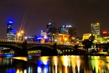 MELBOURNE, AUSTRALIA - DEC 03: Melbourne CBD gece panoraması Flinders istasyonu ile Yarra River 'dan gece, 03 Aralık 2013, Melbourne, Avustralya. Yarra boyunca aydınlatma tanınabilir görünüm sağlar
