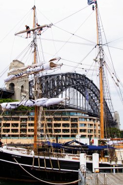 SydNEY - 24 Kasım 2013 Sydney Avustralya 'da Sydney Köprüsü' nün arka planında Sydney Limanı 'nda tekne durağı. Bir grup turist için yelkenli servisi. .