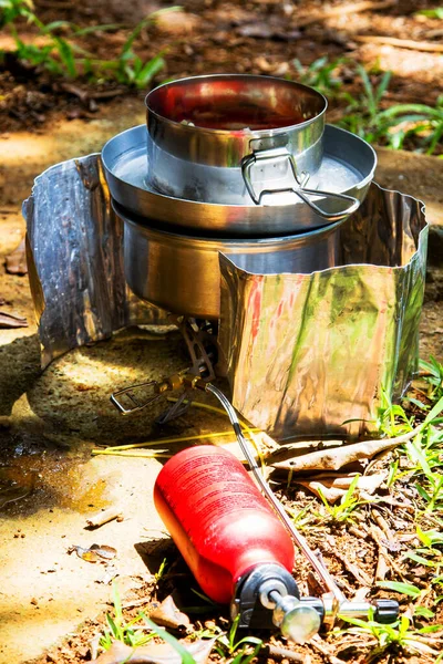 Preparing dinner on a fuel stove at a campsite.