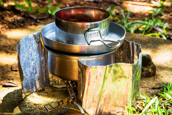 Preparing dinner on a fuel stove at a campsite.