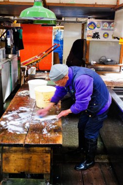 TOKYO - 10 Ocak 2013 'te Tokyo' daki Tsukiji Toptan Deniz Ürünleri ve Balık Pazarı 'nda Tuna işçileri işliyor. Tsukiji Pazarı dünyadaki en büyük toptan balık ve deniz ürünleri pazarıdır..