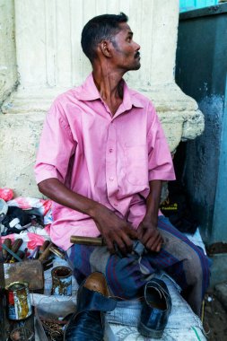 KANDY, SRI LANKA - 27 MAARCH: 27 Mart 2013 'te Kandy, Sri Lanka' da gösterilen sokak atölyesinde eski ayakkabılarını tamir eden ayakkabıcı.
