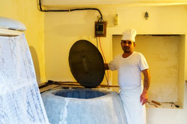 MESTIA, GEORGIA - 28 Haziran: Adam 28 Haziran 'da Mestia, Gürcistan' da taş ocağını gösteriyor. Geleneksel Gürcistan ekmeği tipik bir taş fırınında pişirilir.