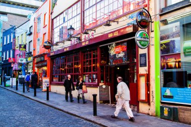 DUBLIN - NOV 11: 11 Kasım 2013 'te Dublin, İrlanda' daki ünlü Temple Bar Quarter 'daki pek çok barın ve barın önünden kimliği belirsiz kişiler geçiyor. Temple Bar dar sokaklarla ortaçağ sokak modelini korudu..