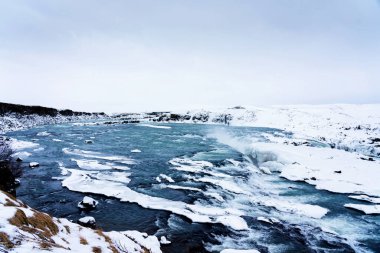 Ülkenin en şehvetli şelalesi Urridafoss 'un panoramik manzarası, kış mevsiminde İzlanda' nın ana yolunun güneyinde.