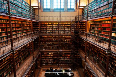 Amsterdam, Hollanda - Kasım 2019: Hollanda 'daki en büyük halk sanatı tarihi araştırma kütüphanesi olan Rijksmuseum Araştırma Kütüphanesi' ndeki kitapları gösteren geniş açılı bir çekim.