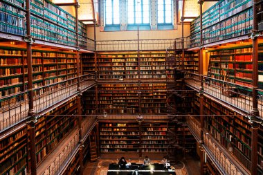 Amsterdam, Hollanda - Kasım 2019: Hollanda 'daki en büyük halk sanatı tarihi araştırma kütüphanesi olan Rijksmuseum Araştırma Kütüphanesi' ndeki kitapları gösteren geniş açılı bir çekim.