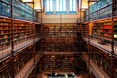 Amsterdam, Hollanda - Kasım 2019: Hollanda 'daki en büyük halk sanatı tarihi araştırma kütüphanesi olan Rijksmuseum Araştırma Kütüphanesi' ndeki kitapları gösteren geniş açılı bir çekim.