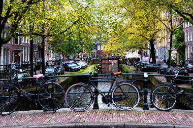 AMSTERDAM, NETHERLANDS - 10 Kasım 2019: Amsterdam, Hollanda 'daki köprüde park edilmiş geleneksel Hollanda bisikleti. Amsterdam 'da birkaç milyon bisiklet vardır..
