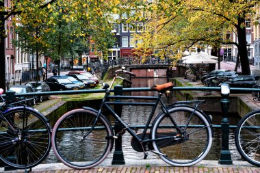 AMSTERDAM, NETHERLANDS - 10 Kasım 2019: Amsterdam, Hollanda 'daki köprüde park edilmiş geleneksel Hollanda bisikleti. Amsterdam 'da birkaç milyon bisiklet vardır..