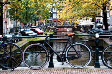 AMSTERDAM, NETHERLANDS - 10 Kasım 2019: Amsterdam, Hollanda 'daki köprüde park edilmiş geleneksel Hollanda bisikleti. Amsterdam 'da birkaç milyon bisiklet vardır..