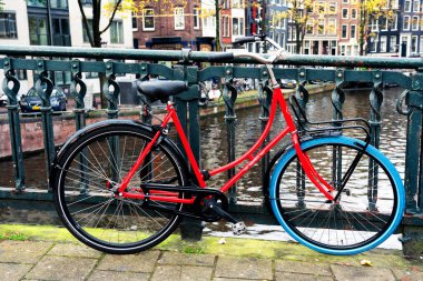 AMSTERDAM, NETHERLANDS - 10 Kasım 2019: Amsterdam, Hollanda 'daki köprüde park edilmiş geleneksel Hollanda bisikleti. Amsterdam 'da birkaç milyon bisiklet vardır..