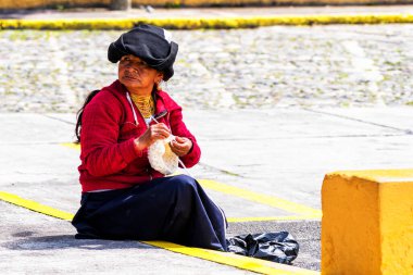 OTAVALO, ECUADOR - NOV 6, 2019: Geleneksel giysiler içinde tanımlanamayan Ekvadorlu kadın Otavalo Market 'te çalışıyor. Ekvador halkının% 71,9 'u Mestizo etnik grubuna ait.