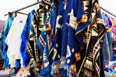 Ekvador 'daki Otavalo zanaatkar pazarında farklı renklerde geleneksel pançolar sergileniyor.