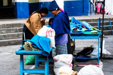 OTAVALO, ECUADOR - NOV 6, 2019: Geleneksel giysiler içinde tanımlanamayan Ekvadorlu kadın Otavalo Market 'te çalışıyor. Ekvador halkının% 71,9 'u Mestizo etnik grubuna ait.