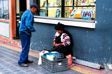 OTAVALO, ECUADOR - NOV 6, 2019: Geleneksel giysiler içinde tanımlanamayan Ekvadorlu kadın Otavalo Market 'te çalışıyor. Ekvador halkının% 71,9 'u Mestizo etnik grubuna ait.