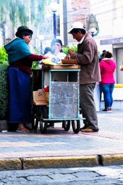 OTAVALO, ECUADOR - NOV 6, 2019: Geleneksel giysiler içinde tanımlanamayan Ekvadorlu kadın Otavalo Market 'te çalışıyor. Ekvador halkının% 71,9 'u Mestizo etnik grubuna ait.