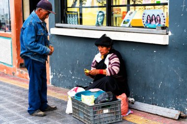 OTAVALO, ECUADOR - NOV 6, 2019: Geleneksel giysiler içinde tanımlanamayan Ekvadorlu kadın Otavalo Market 'te çalışıyor. Ekvador halkının% 71,9 'u Mestizo etnik grubuna ait.