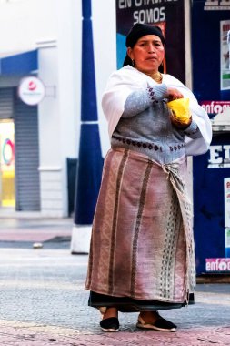 OTAVALO, ECUADOR - NOV 6, 2019: Geleneksel giysiler içinde tanımlanamayan Ekvadorlu kadın Otavalo Market 'te çalışıyor. Ekvador halkının% 71,9 'u Mestizo etnik grubuna ait.