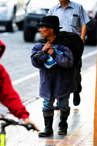 OTAVALO, ECUADOR - NOV 6, 2019: Geleneksel kıyafetler içindeki tanımlanamayan Ekvadorlu adam Otavalo Market 'te çalışıyor. Ekvador halkının% 71,9 'u Mestizo etnik grubuna ait.