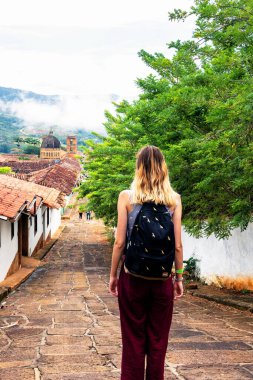 BARICHARA, COLOMBIA - 13 Kasım 2019: Genç maceracı kız, Kolombiya 'nın Santander ilindeki Barichara kentinin manzarasına hayran..