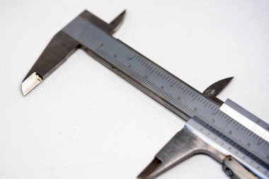 Calliper veya Caliper. Gümüş çelikten yapılmış hassas ölçüm aletleri. Beyaz bir arkaplanda izole edilmiş.