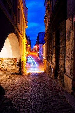 BIELSKO-BIALA, POLAND - 9 Nisan 2019: Bielsko Biala pazar meydanının gece görüşü ve parlayan dar sokaklar. Polonya