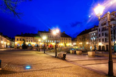 BIELSKO-BIALA, POLAND - 9 Nisan 2019: Bielsko Biala pazar meydanının gece görüşü ve parlayan dar sokaklar. Polonya