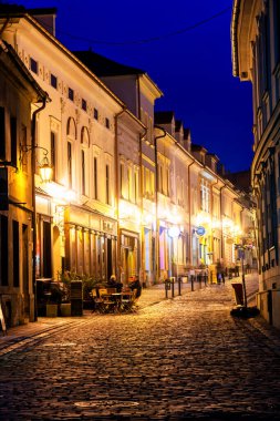 BIELSKO-BIALA, POLAND - 9 Nisan 2019: Bielsko Biala pazar meydanının gece görüşü ve parlayan dar sokaklar. Polonya
