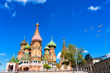 St. Moskova, Rusya 'daki Kızıl Meydan' daki Basil Katedrali. Zafer Günü hava gösterisinde arka planda uçan uçaklar