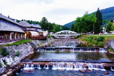 SpINDLERUV MLYN, CZECH REPUBLIC - 13 AUG 2019: Elbe (Lave) nehri Spindleruv Mlyn şehir merkezi boyunca akar - popüler turist yürüyüşü ve kış kayak merkezi. Krkonose Dağları