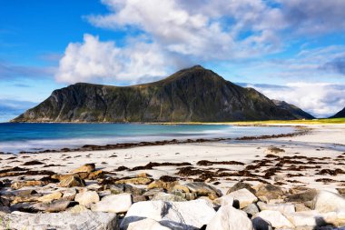 Kristal turkuaz suyla yıkanmış beyaz kumlar. Norveç, Lofoten Adaları 'ndaki Ramberg plajından deniz manzarası