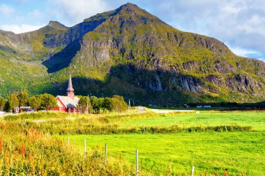 Flakstad Kilisesi 'nin arka planında dağlar var. Arktik, Flakstadoy, Lofoten Adaları, Kuzey Kutup Dairesi, Norveç' te XVIII.