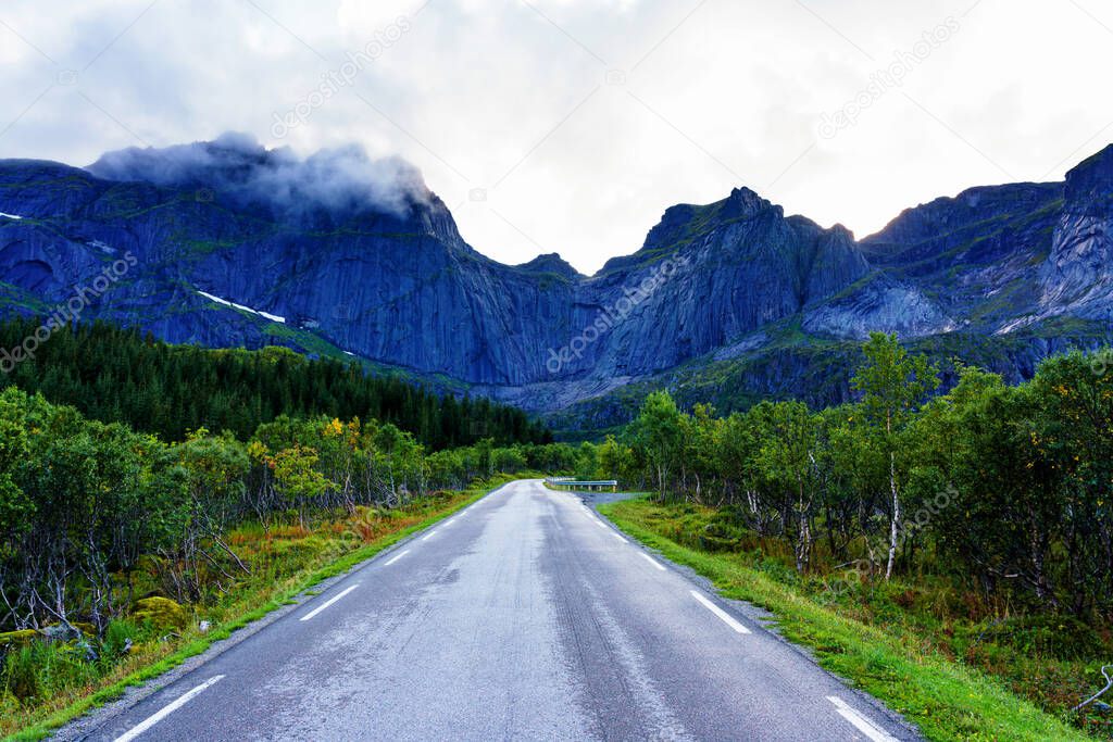 Scenic asphalt road through the beautiful view of mountain in Lofoten island, Norway during autumn. Concept of roadtrip, travel, vacation, adventure