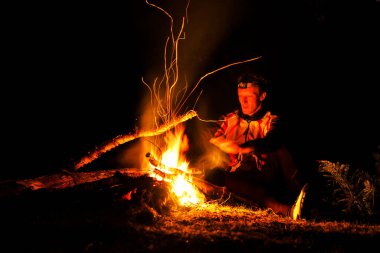LOFOTEN, NORway - 10 Eylül 2019: ormanda şenlik ateşi yakan adam
