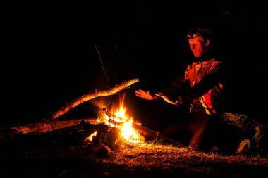 LOFOTEN, NORway - 10 Eylül 2019: ormanda şenlik ateşi yakan adam