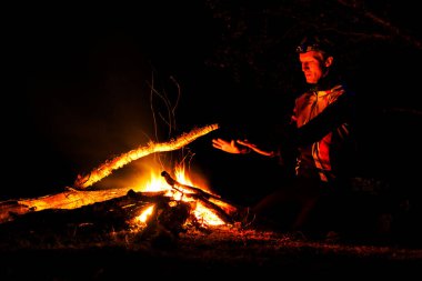 LOFOTEN, NORway - 10 Eylül 2019: ormanda şenlik ateşi yakan adam