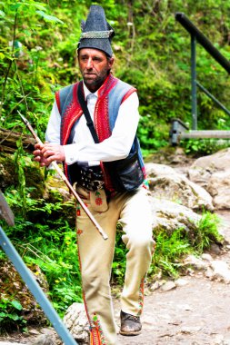 SZCZAWNICA, POLAND - 2 Haziran 2019: Pieniny Dağları Ulusal Parkı 'nda dağ yürüyüşü yaparken bölgesel kıyafetler giyen adam