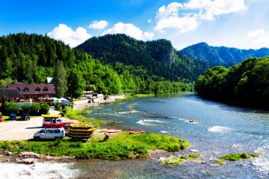 SZCZAWNICA, POLAND - 2 Haziran 2019: Szczawnica, Polonya 'daki Dunajec nehri. Geleneksel ahşap bir teknede rafting yapmak Pieniny Ulusal Parkı 'nda popüler bir turistik cazibedir.