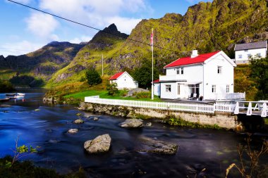 Reine, Lofoten, Norveç 'te akan derenin yanındaki beyaz yazlık evde.