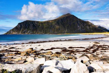 Kristal turkuaz suyla yıkanmış beyaz kumlar. Norveç, Lofoten Adaları 'ndaki Ramberg plajından deniz manzarası