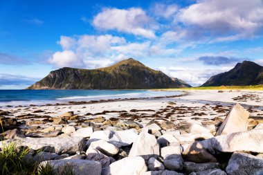 Kristal turkuaz suyla yıkanmış beyaz kumlar. Norveç, Lofoten Adaları 'ndaki Ramberg plajından deniz manzarası
