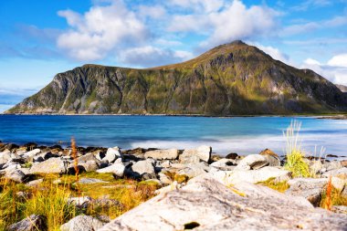 Kristal turkuaz suyla yıkanmış beyaz kumlar. Norveç, Lofoten Adaları 'ndaki Ramberg plajından deniz manzarası