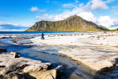 Kristal turkuaz suyla yıkanmış beyaz kumlar. Norveç, Lofoten Adaları 'ndaki Ramberg plajından deniz manzarası