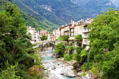 CHIAVENNA, ITALY - 09 Ağustos 2014 'te İtalya' nın Chiavenna kentindeki evlerin arasından akan küçük bir nehre bakın. Chiavenna yüksek Alplere açılan bir kapıdır..