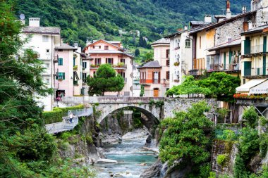 CHIAVENNA, ITALY - 09 Ağustos 2014 'te İtalya' nın Chiavenna kentindeki evlerin arasından akan küçük bir nehre bakın. Chiavenna yüksek Alplere açılan bir kapıdır..
