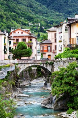 CHIAVENNA, ITALY - 09 Ağustos 2014 'te İtalya' nın Chiavenna kentindeki evlerin arasından akan küçük bir nehre bakın. Chiavenna yüksek Alplere açılan bir kapıdır..