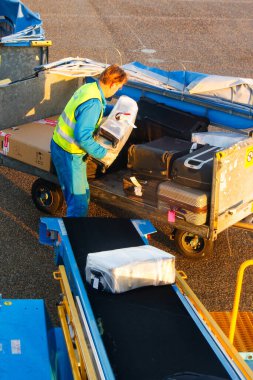 AMSTERDAM, NETHERLANDS - NOVEMBER 08: 08 Kasım 2014 tarihinde Hollanda 'nın Amsterdam Schiphol havaalanında bir uçaktan bavul indiren adam. Schiphol, Avrupa 'nın dördüncü büyük havaalanıdır..