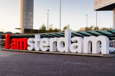 Kırmızı ve beyaz görünüm Ben Amsterdam işareti Schiphol havaalanı varış / çıkış güvertesi.